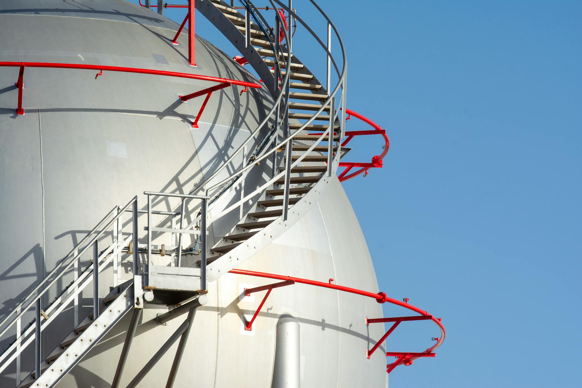 a large industrial tank with stairs and a red railing